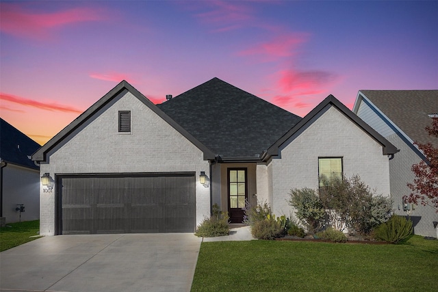 view of front of property featuring a garage and a yard