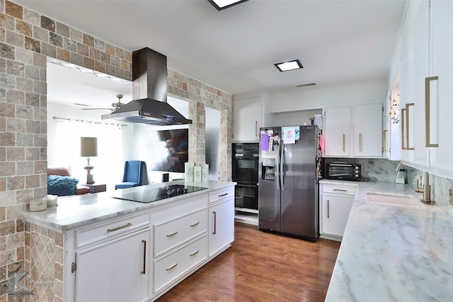 kitchen with black appliances, white cabinets, wall chimney range hood, dark hardwood / wood-style floors, and tasteful backsplash