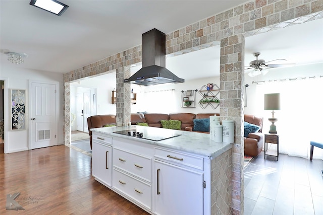 kitchen featuring ceiling fan, wall chimney range hood, dark hardwood / wood-style floors, black electric cooktop, and white cabinets