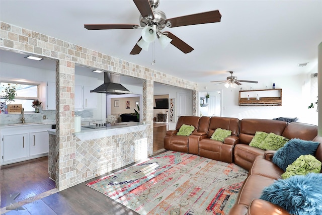 living room with dark hardwood / wood-style floors, ceiling fan, and sink