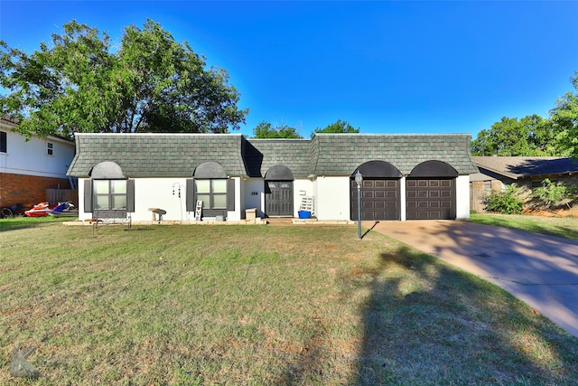 view of front of property with a front yard and a garage