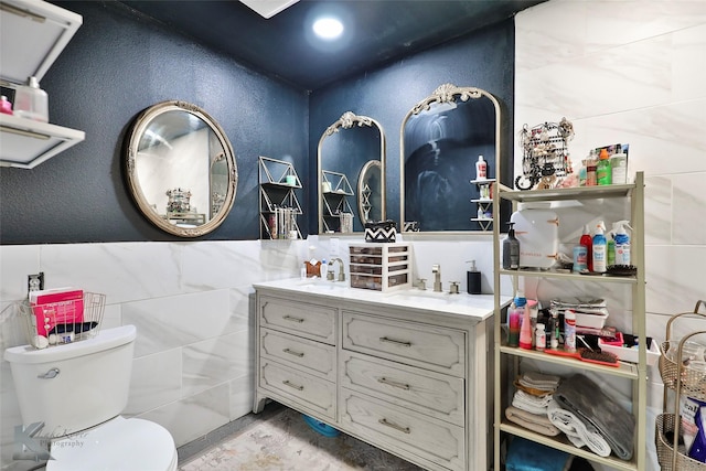 bathroom with vanity, tile walls, and toilet