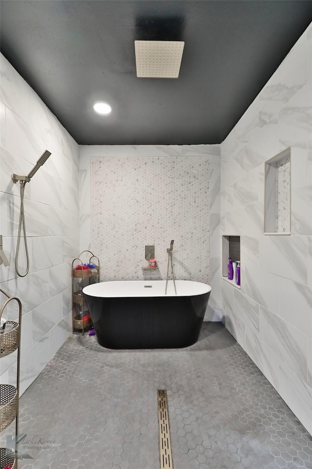 bathroom featuring tile walls and independent shower and bath