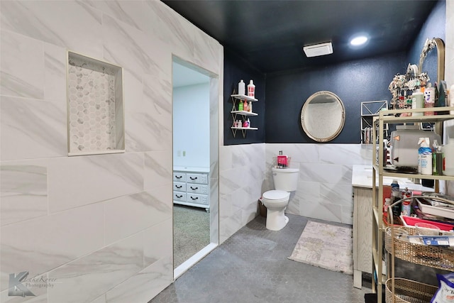 bathroom featuring toilet, tile walls, and concrete floors