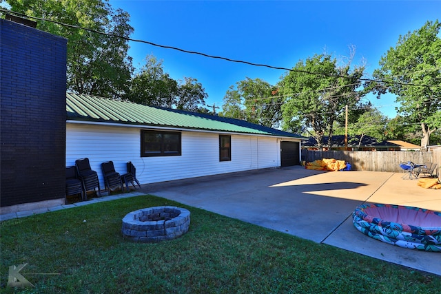 exterior space featuring a garage and an outdoor fire pit