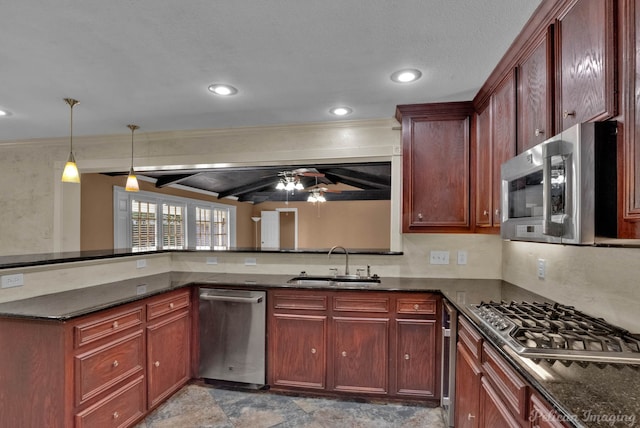 kitchen with sink, ceiling fan, hanging light fixtures, stainless steel appliances, and dark stone counters