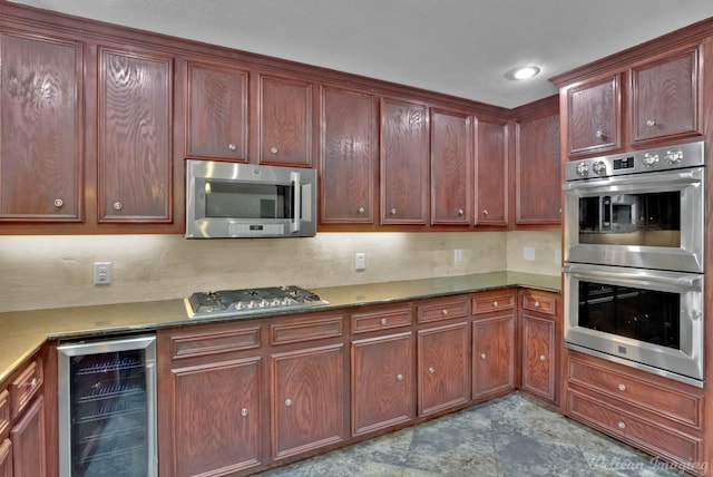 kitchen featuring stainless steel appliances, wine cooler, and dark stone counters