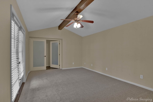 unfurnished room featuring ceiling fan, light colored carpet, and vaulted ceiling with beams