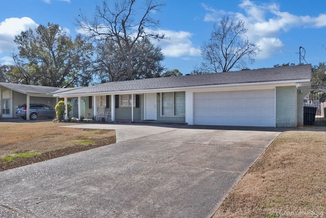 ranch-style house featuring a porch, a garage, and a front yard