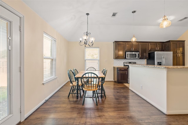 dining room featuring lofted ceiling, dark wood-type flooring, and a chandelier