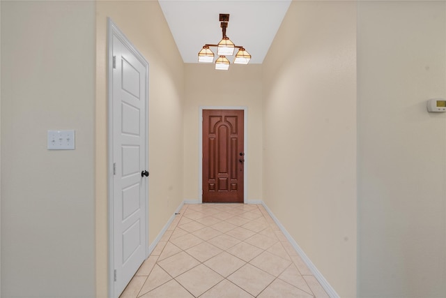 doorway with light tile patterned floors and an inviting chandelier