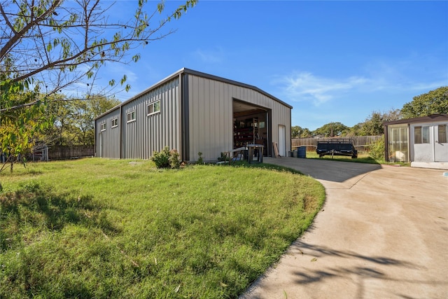 view of outdoor structure featuring a lawn and a garage