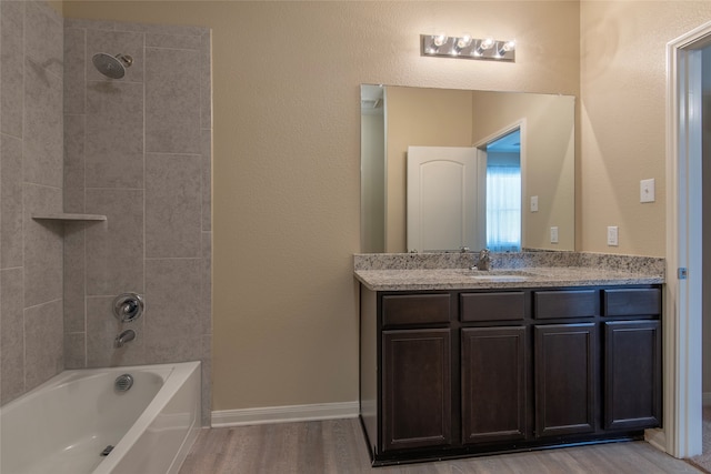 bathroom featuring vanity, tiled shower / bath, and hardwood / wood-style flooring