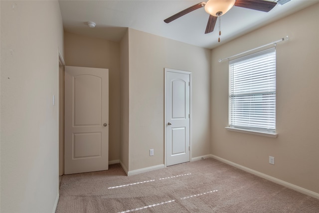 unfurnished bedroom featuring ceiling fan and light carpet