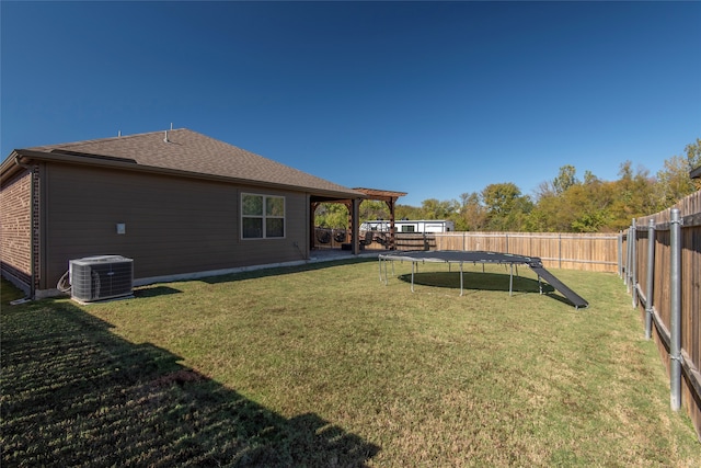 view of yard featuring central AC unit and a trampoline