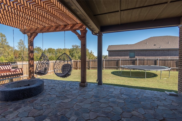 view of patio featuring an outdoor fire pit, a pergola, and a trampoline