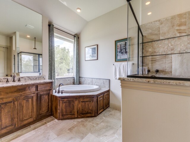 bathroom with vanity, independent shower and bath, and vaulted ceiling