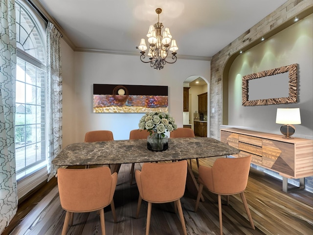 dining room with a healthy amount of sunlight, ornamental molding, dark hardwood / wood-style flooring, and an inviting chandelier