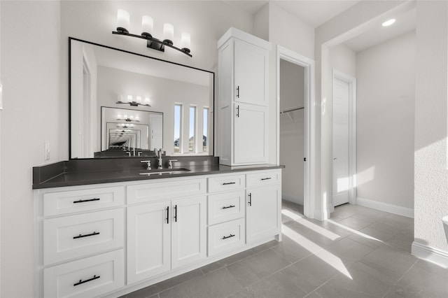 full bathroom featuring baseboards, tile patterned floors, and vanity