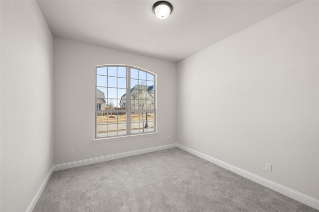 carpeted empty room with baseboards