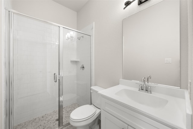 bathroom featuring vanity, a stall shower, and toilet