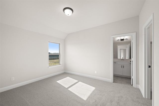unfurnished bedroom featuring baseboards, light carpet, and a sink