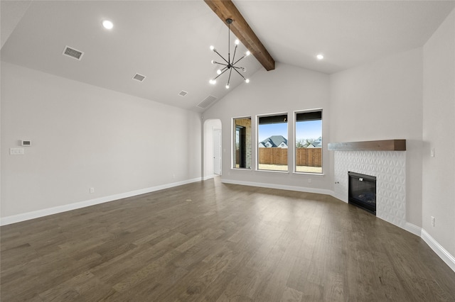 unfurnished living room with a glass covered fireplace, beamed ceiling, a chandelier, and visible vents