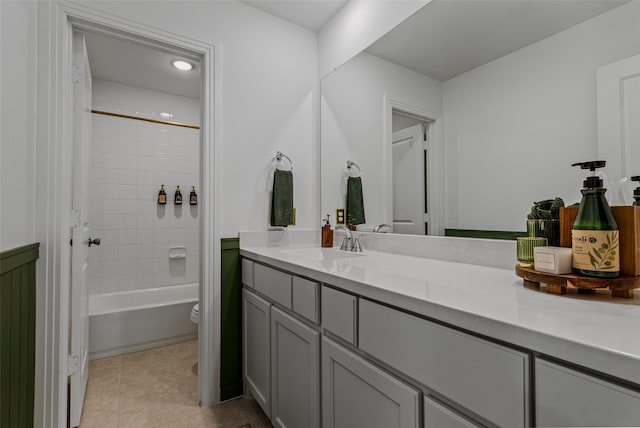 full bathroom with toilet, tiled shower / bath, vanity, and tile patterned floors