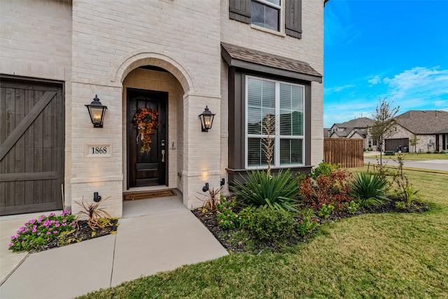 property entrance with a lawn