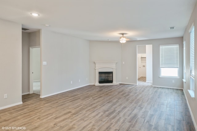 unfurnished living room with light hardwood / wood-style flooring and ceiling fan