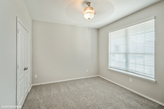 spare room featuring light carpet and ceiling fan