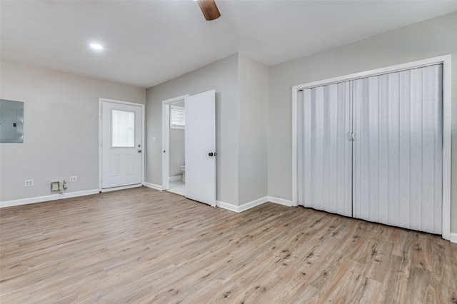 unfurnished bedroom with ceiling fan, electric panel, and light hardwood / wood-style flooring