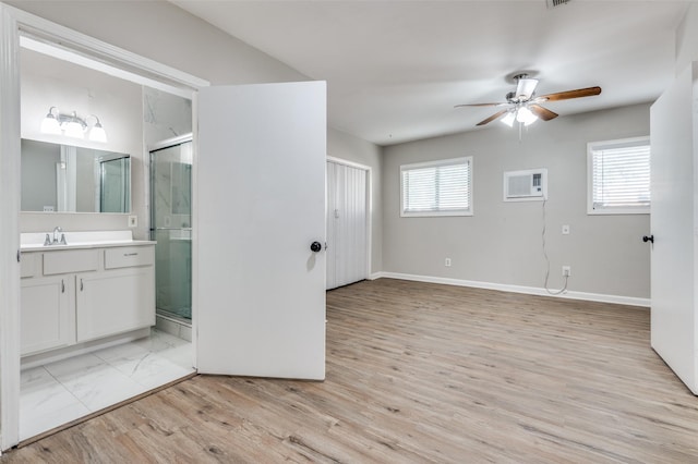 bathroom featuring vanity, hardwood / wood-style floors, a shower with shower door, and a wall mounted AC