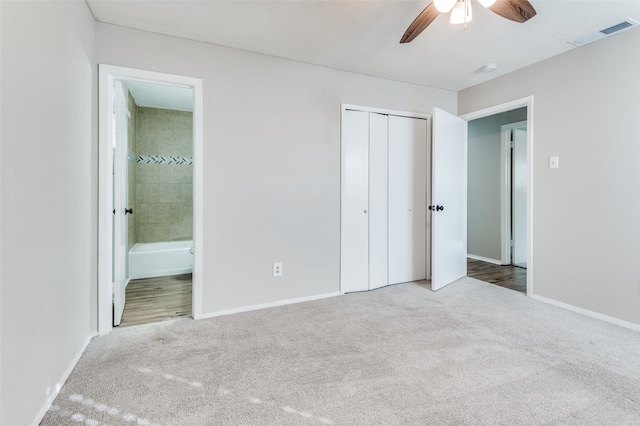 unfurnished bedroom with ensuite bathroom, ceiling fan, carpet floors, and a closet