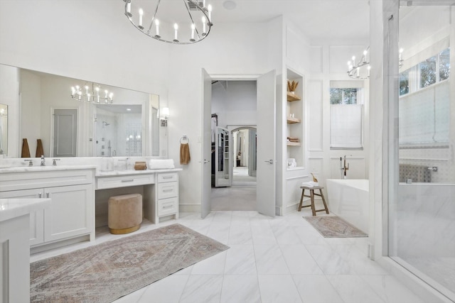 bathroom featuring vanity, shower with separate bathtub, a chandelier, and built in shelves