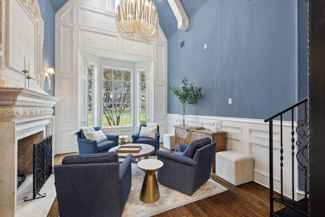 living room with an inviting chandelier, high vaulted ceiling, and a premium fireplace