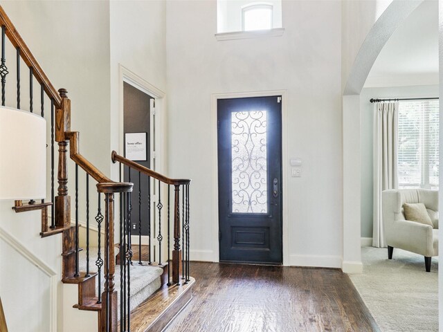 entrance foyer featuring a towering ceiling and dark hardwood / wood-style flooring