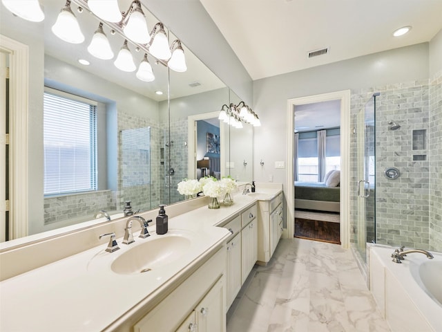 bathroom featuring vanity, independent shower and bath, and a healthy amount of sunlight