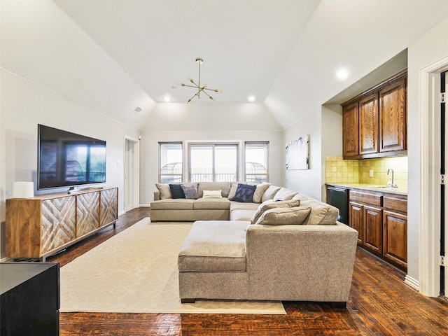 living room with dark hardwood / wood-style flooring, lofted ceiling, and a chandelier