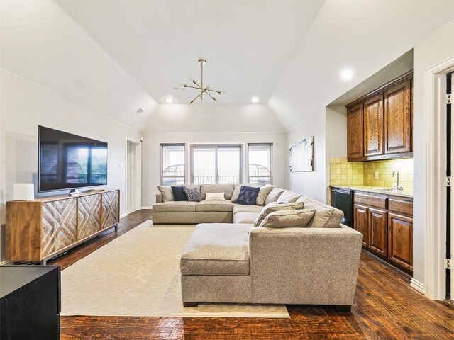 living room with dark hardwood / wood-style flooring, a chandelier, and vaulted ceiling