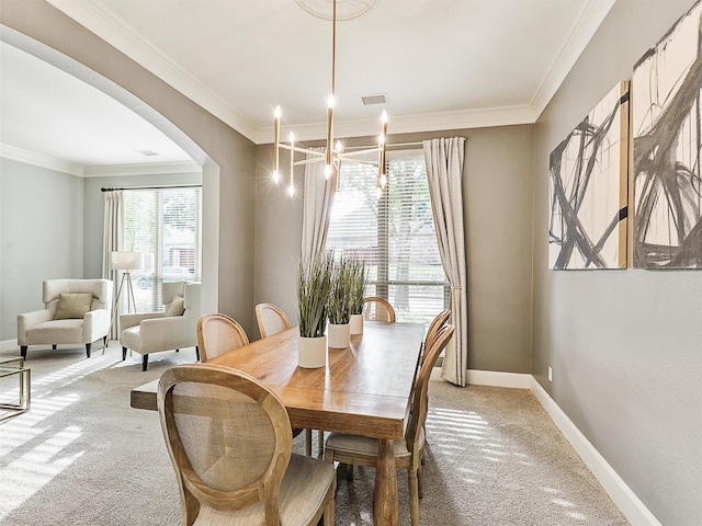 dining area featuring carpet, crown molding, and a chandelier