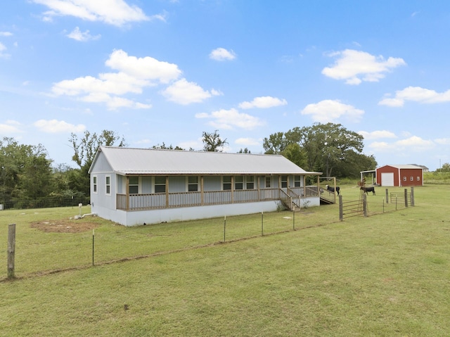 exterior space featuring a porch, a front yard, a garage, an outdoor structure, and fence