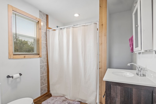 bathroom with vanity, walk in shower, and toilet