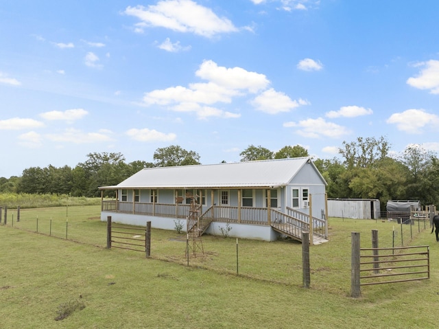 farmhouse-style home featuring covered porch, fence, a front yard, and stairs