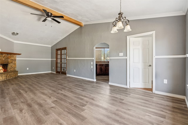 unfurnished living room featuring vaulted ceiling with beams, ornamental molding, hardwood / wood-style floors, a fireplace, and ceiling fan with notable chandelier