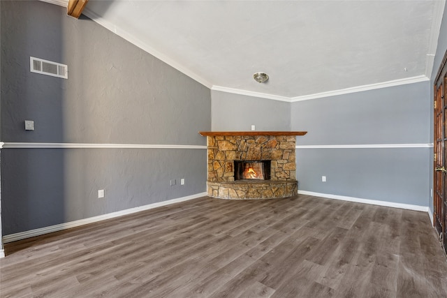 unfurnished living room featuring a stone fireplace, hardwood / wood-style floors, and ornamental molding