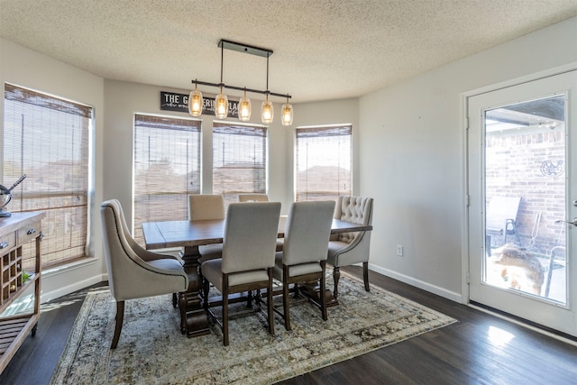 dining room featuring dark wood-type flooring and a textured ceiling