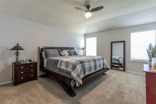 carpeted bedroom with lofted ceiling, ceiling fan, and a textured ceiling