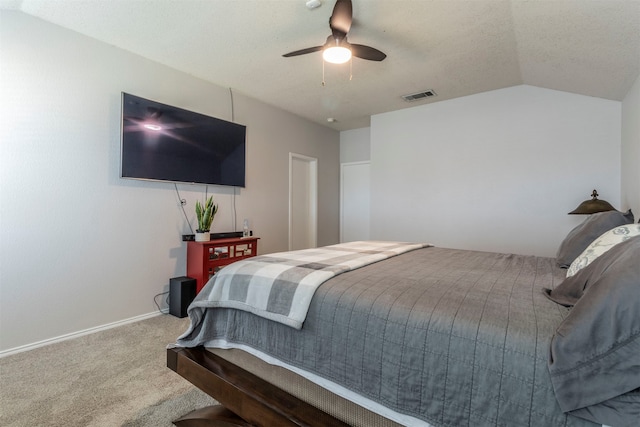 bedroom featuring ceiling fan, lofted ceiling, carpet flooring, and a textured ceiling