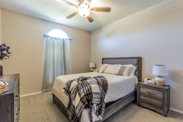 carpeted bedroom with ceiling fan and a textured ceiling